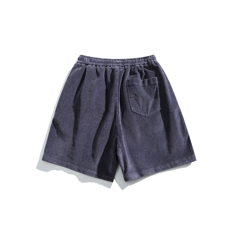 Slate blue-gray corduroy shorts shown from the back, with an elastic waistband and one patch pocket.