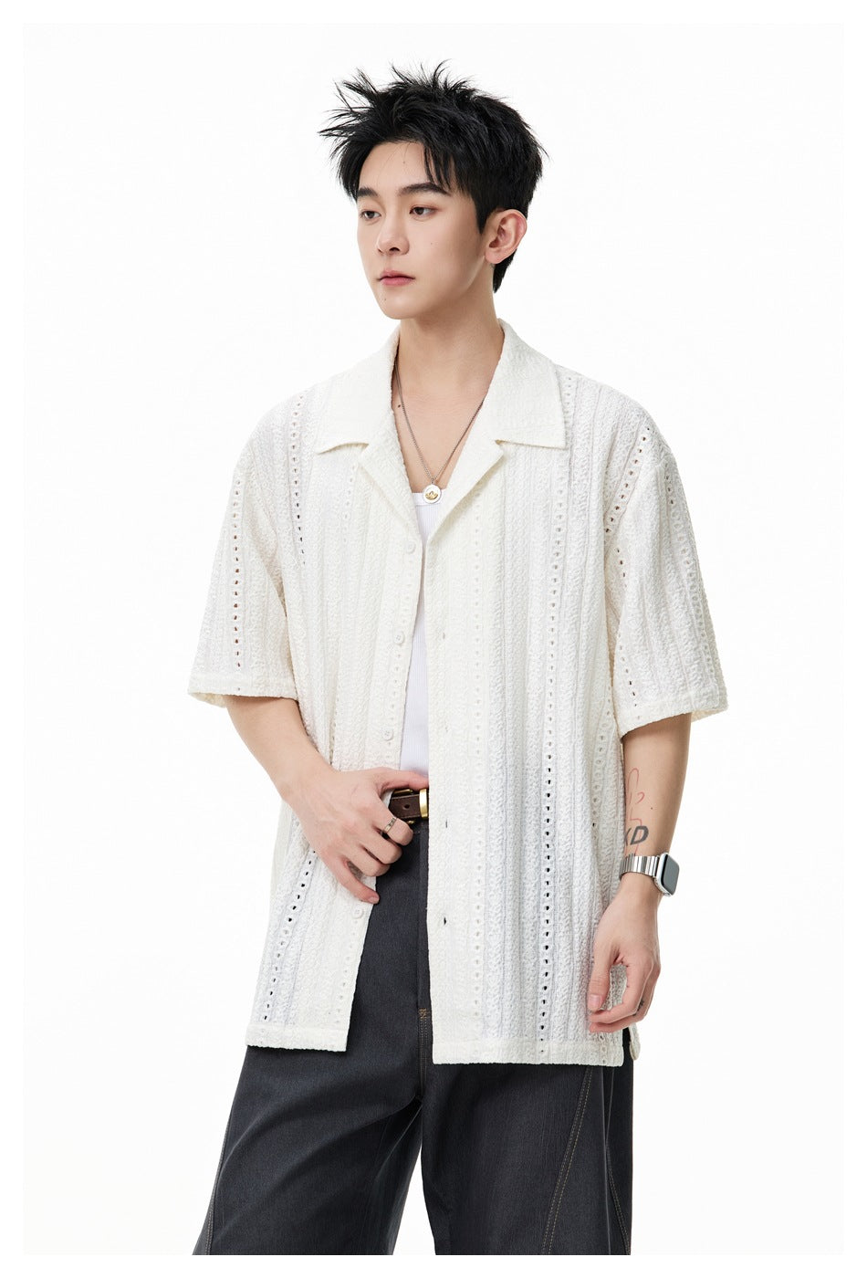 Model wearing an ivory short-sleeve openwork shirt with a notched collar and buttons, shown from the waist up.