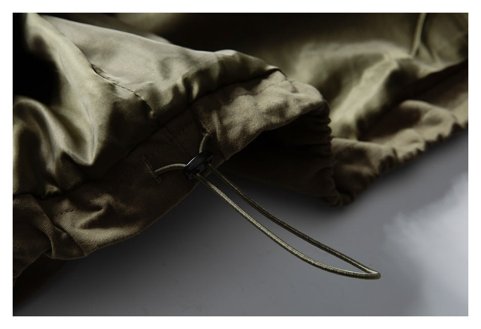 Close-up of the olive jacket's adjustable hem drawcord and cord lock.