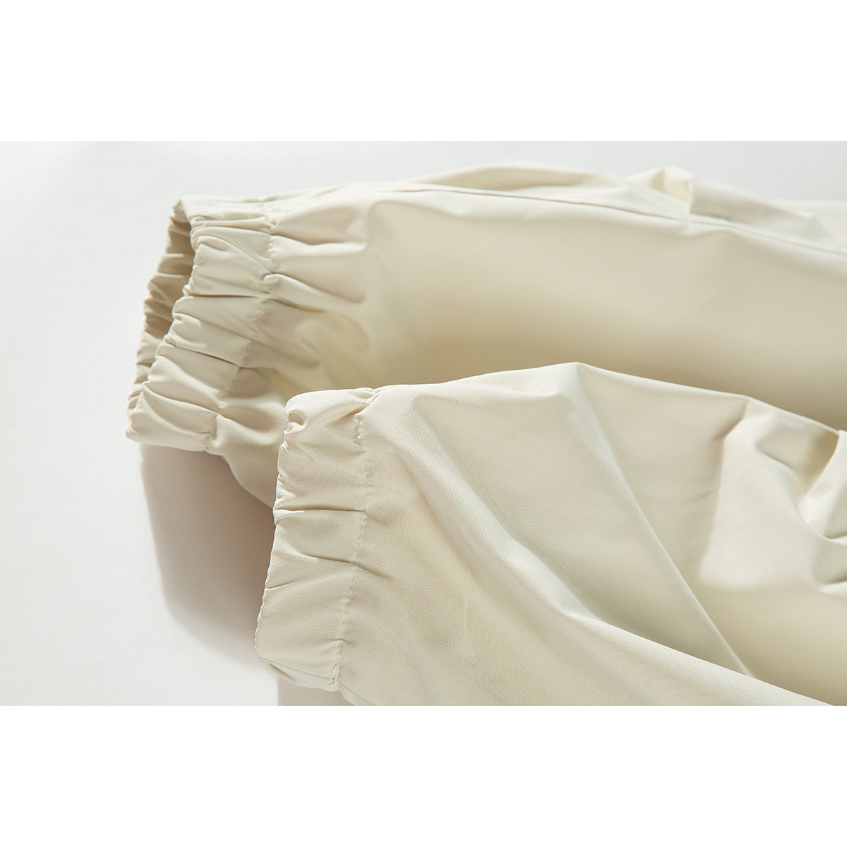 Close-up of the ivory jacket fabric and gathered elasticized sleeve cuffs.
