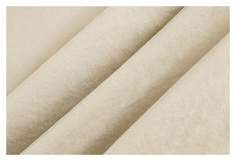 Close-up showing the fine diagonal weave and texture of beige garment fabric.
