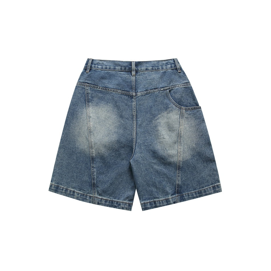 Back view of blue washed denim shorts with faded patches, yoke seam and one angled back pocket
