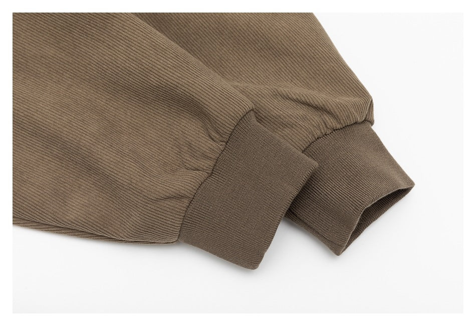 Close-up of a taupe ribbed sleeve ending in a wide knit cuff.