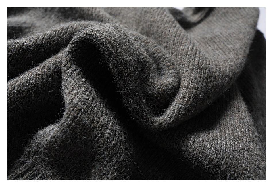 Close-up of fuzzy charcoal gray knit fabric folded to show its soft, textured surface.