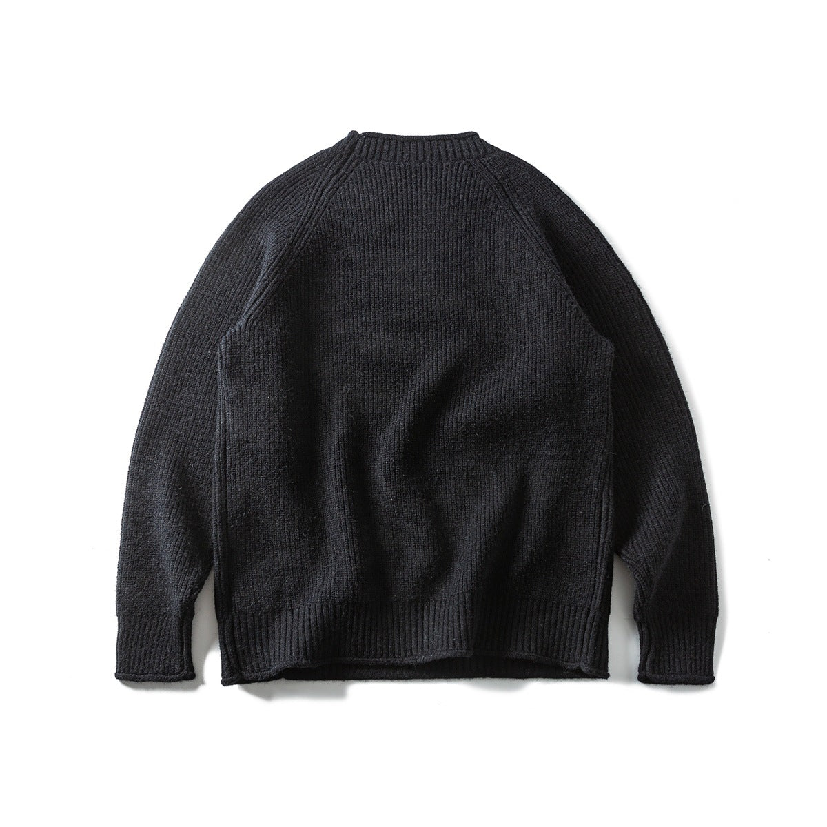Black textured crewneck sweater laid flat, front view, with raglan sleeves and ribbed cuffs, collar and hem.