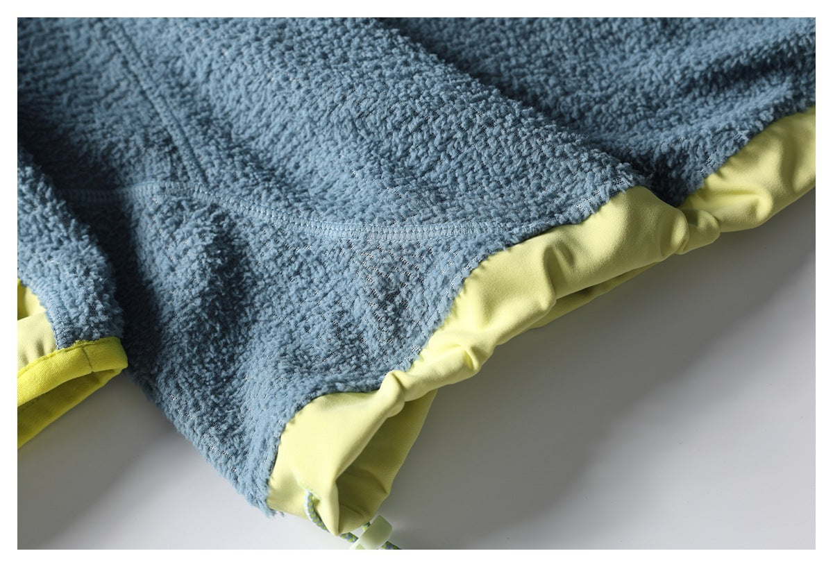 Close-up of blue textured jacket fabric and stitching beside a pale yellow hem panel.