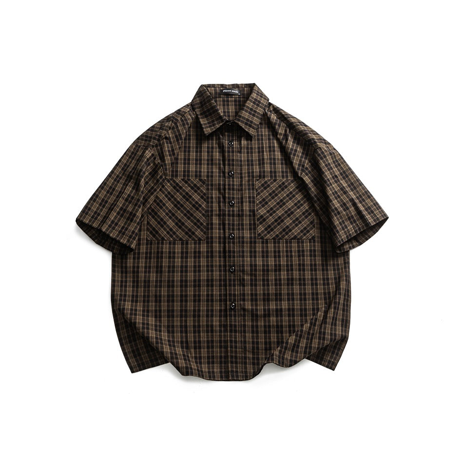 Black and tan plaid short-sleeve button-up shirt with two chest patch pockets, flat lay on white
