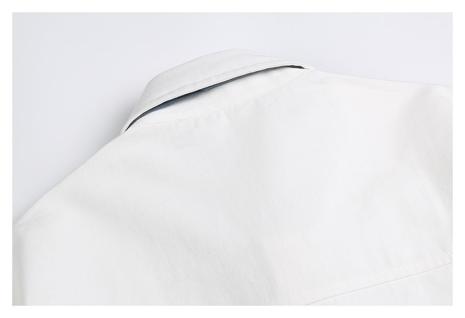 Close-up of the upper back of a white garment, showing the collar and horizontal seam.