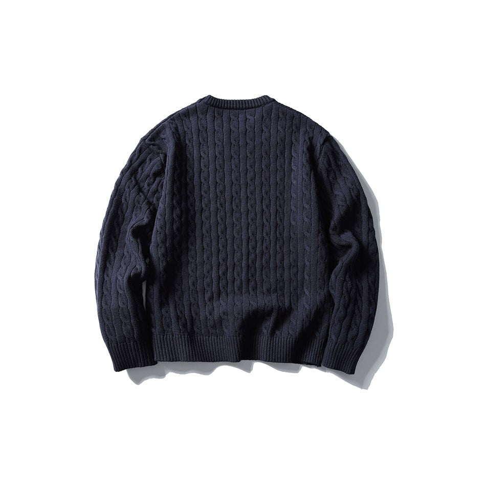 Navy cable-knit crew-neck sweater laid flat, back view