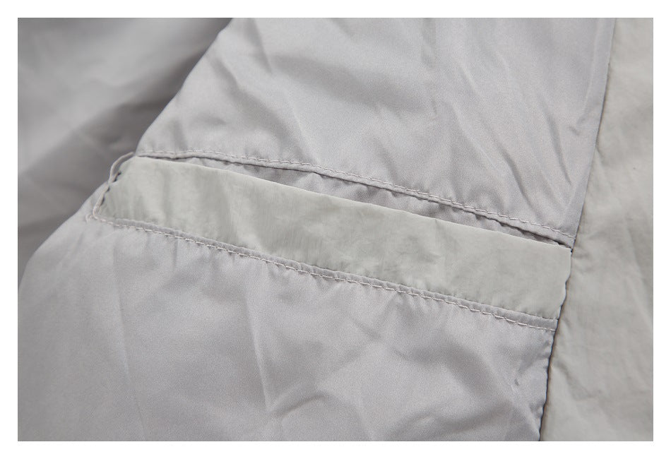 Close-up of a stitched pocket opening on light gray jacket fabric.