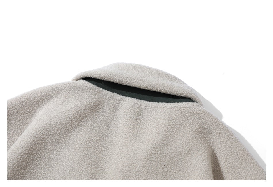 Close-up of the cream fleece pullover's back collar with a narrow dark green inset.