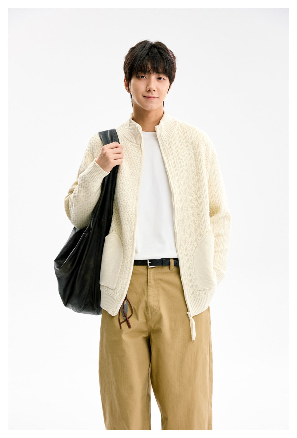 Model wearing an ivory textured knit zip cardigan with ribbed cuffs and large front pockets.