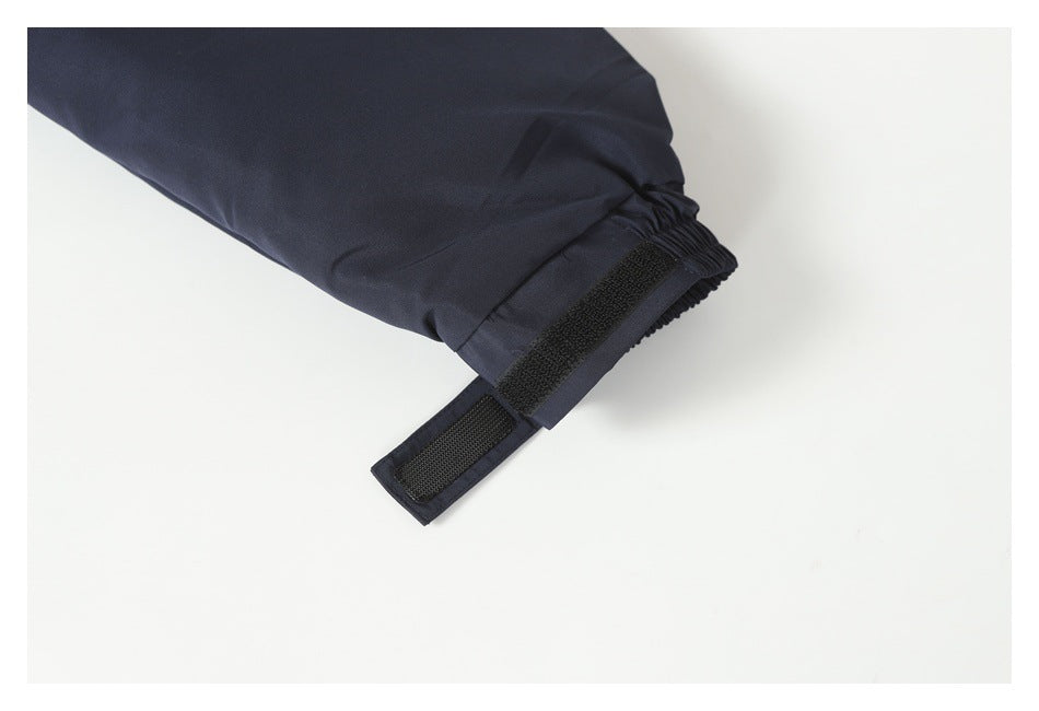 Close-up of a navy jacket sleeve cuff with elastic gathering and an adjustable hook-and-loop tab.
