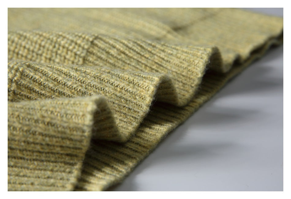 Close-up of layered ribbed knit edges in pale olive-beige, showing the garment's textured trim.