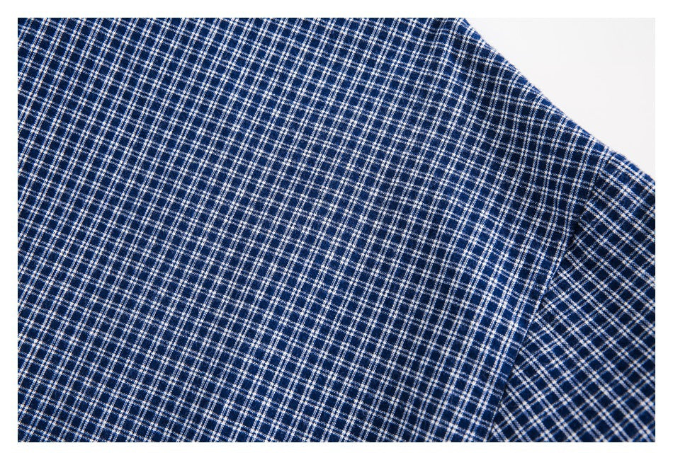 Close-up of navy and white checked shirt fabric with a curved seam near the sleeve.