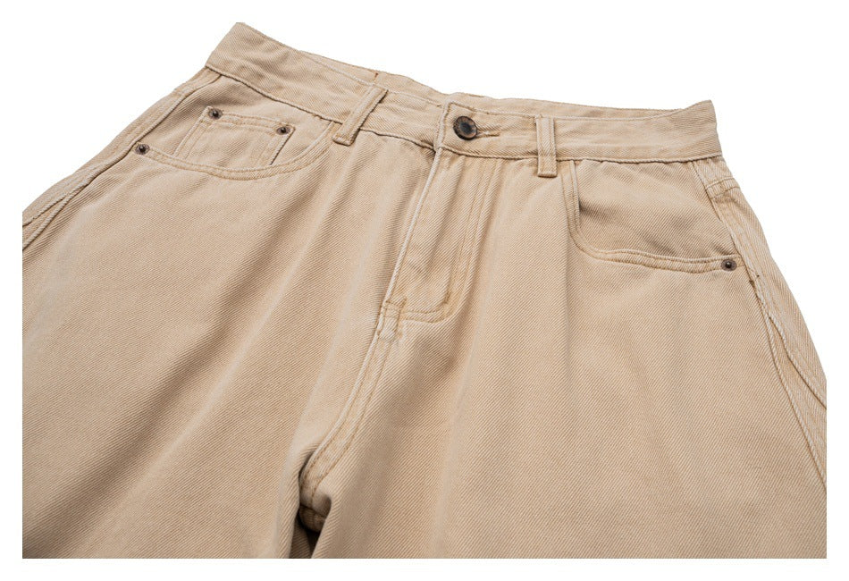 Close-up of the front waistband and pockets of beige pants.