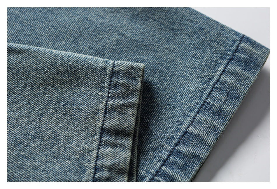 Close-up of blue denim with a folded edge and parallel stitching.