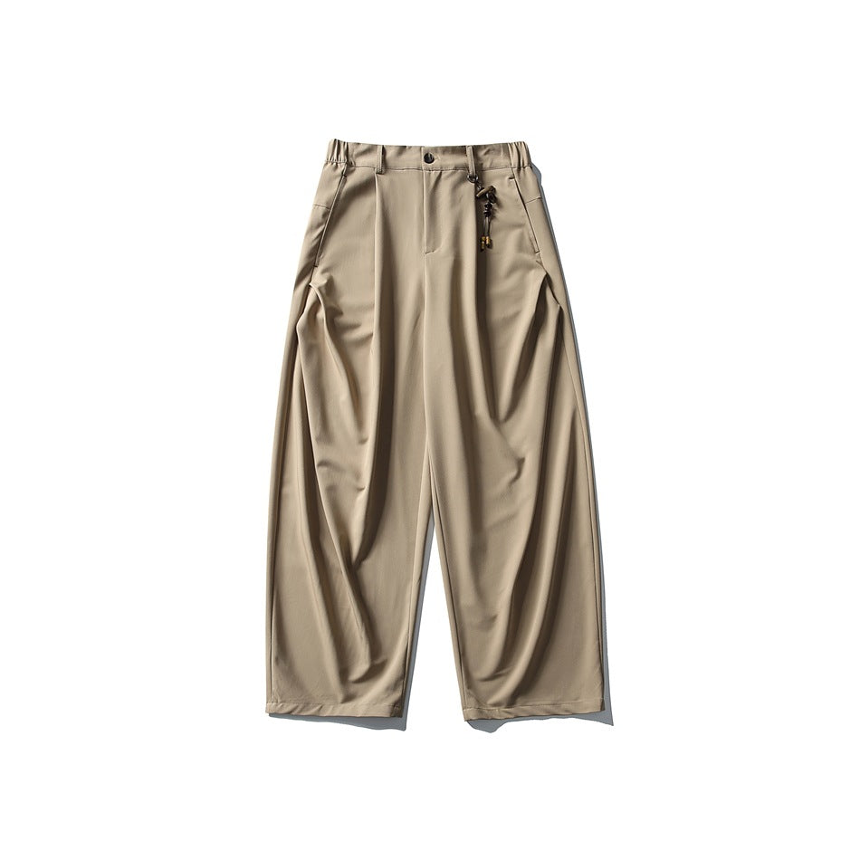 Khaki wide-leg pleated trousers flat lay with elastic waistband and beaded charm