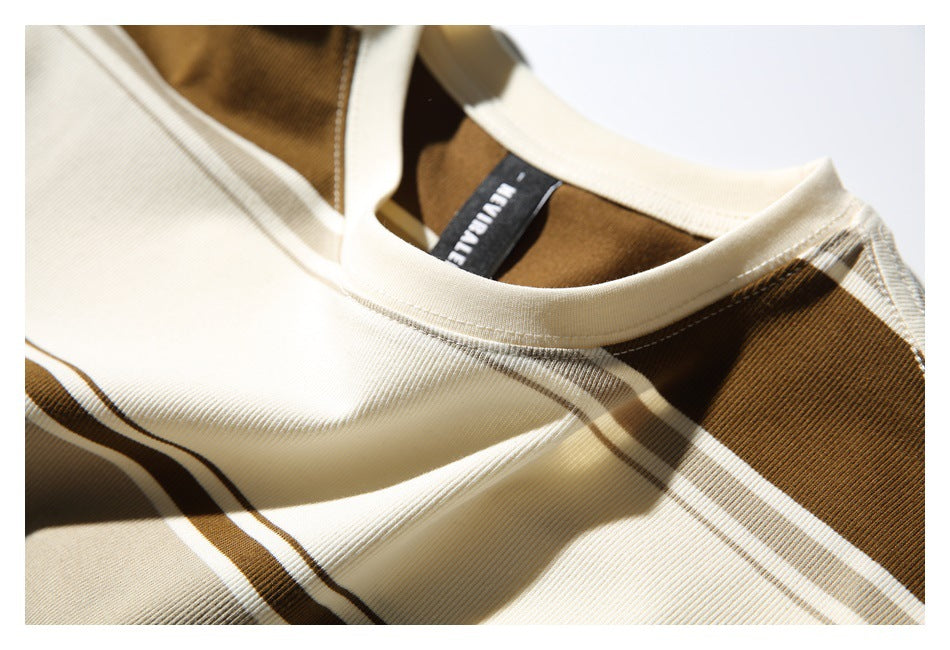 Angled close-up of a cream crew neck, brown shoulder panel, and black neck label on a striped top.