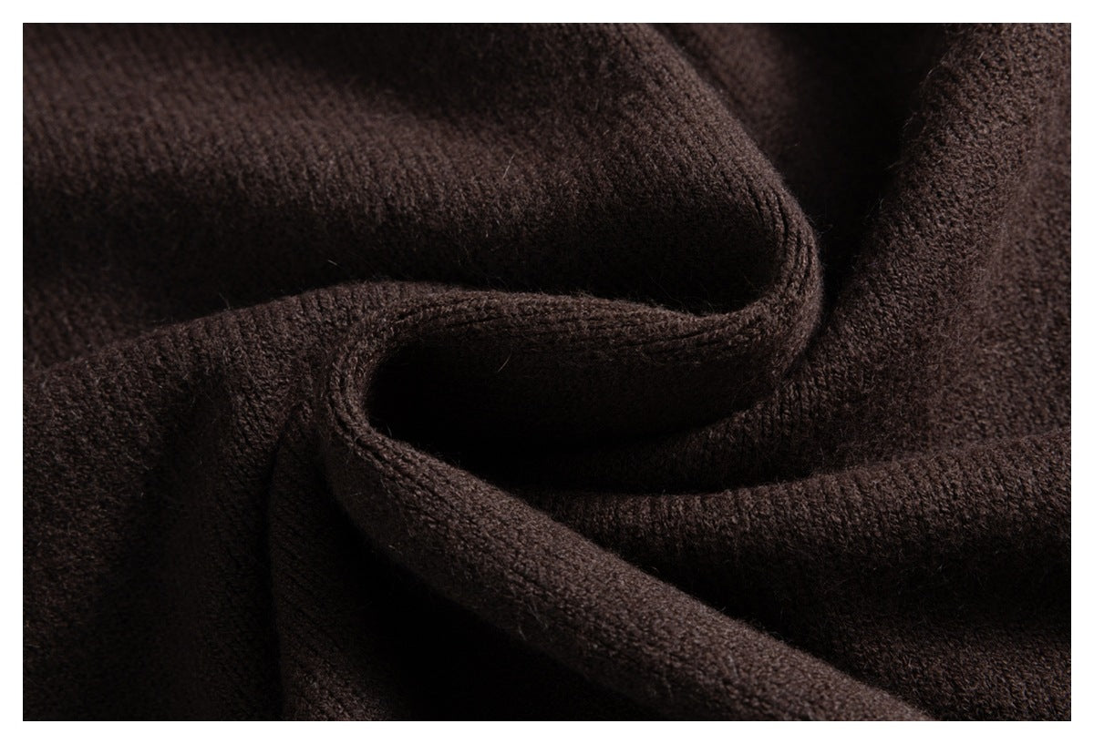 Close-up of dark brown knit fabric draped into soft folds, showing its textured surface.