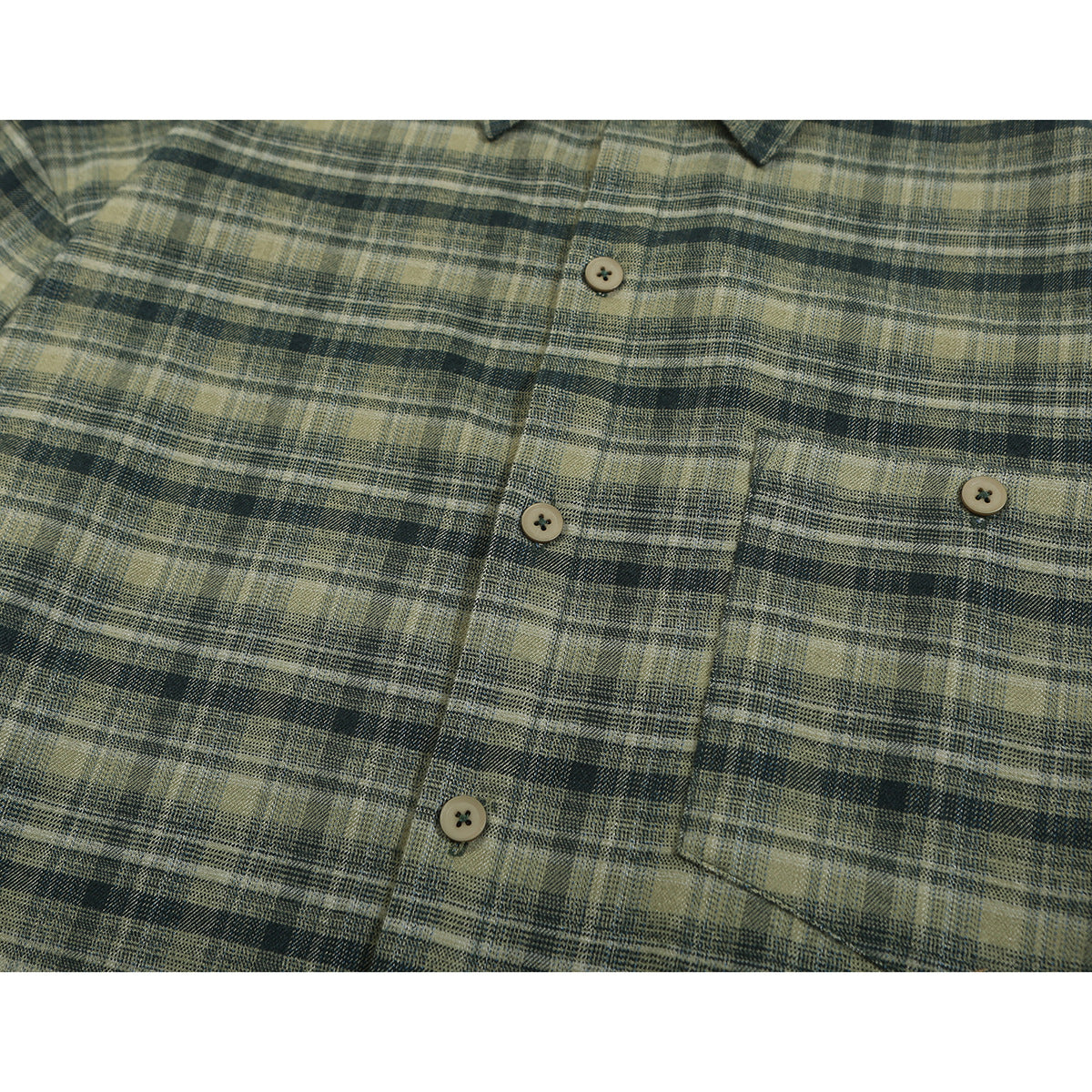 Close-up of an olive and charcoal plaid shirt front with buttons and a single chest pocket.