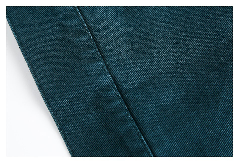 Close-up of dark teal ribbed fabric showing a diagonal edge and seam.