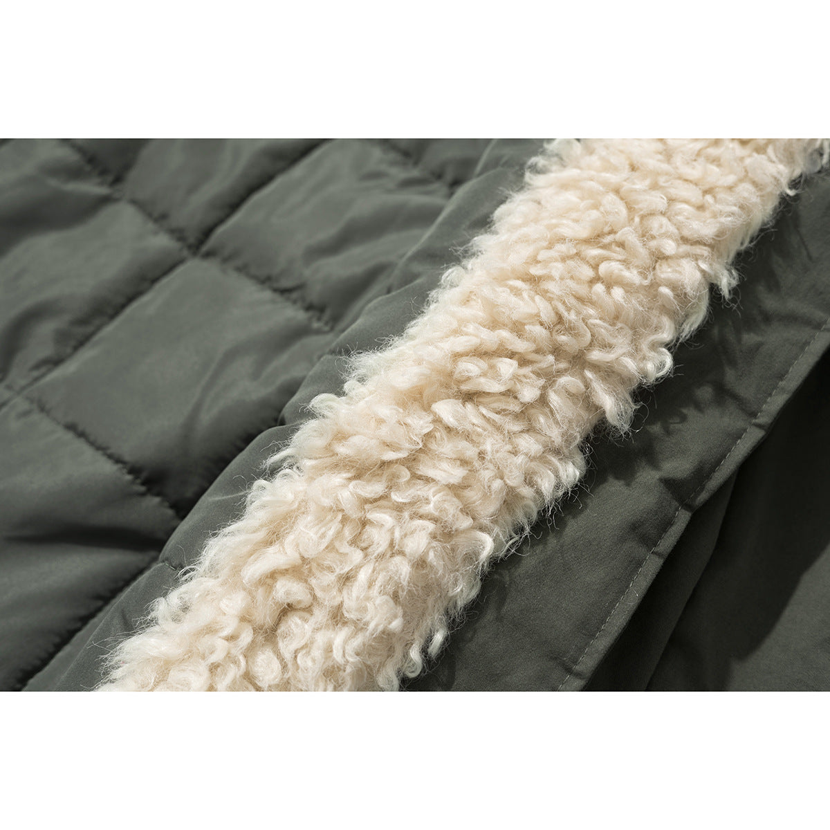 Close-up of cream curly lining beside the quilted olive outer fabric of a jacket.