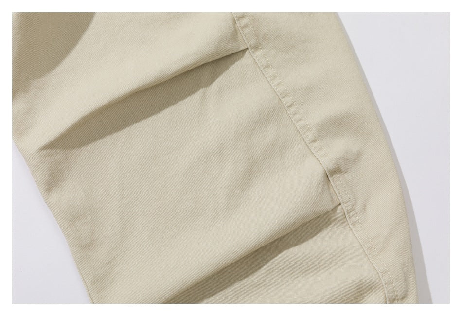 Close-up of an ivory garment panel with a stitched seam and soft folds.