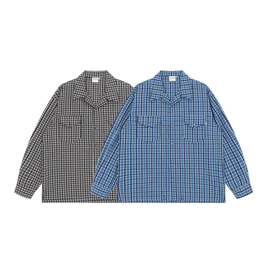 Two long-sleeve plaid button-up shirts shown from the front, one black and gray and one blue, each with two chest pockets.
