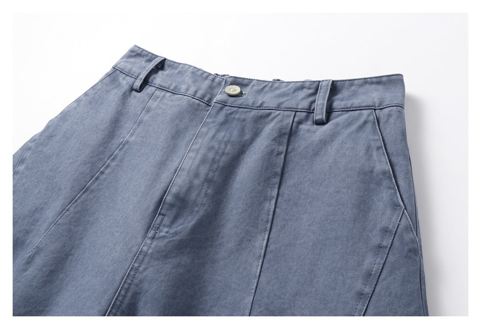 Cropped front view of blue-gray trousers with a buttoned waistband, belt loops, front seams, and angled pockets.