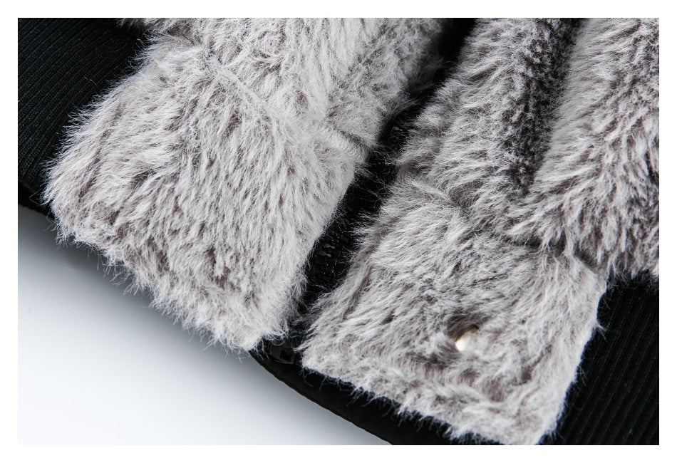 Close-up of shaggy gray garment edges over black ribbed fabric, with a small light-colored snap.