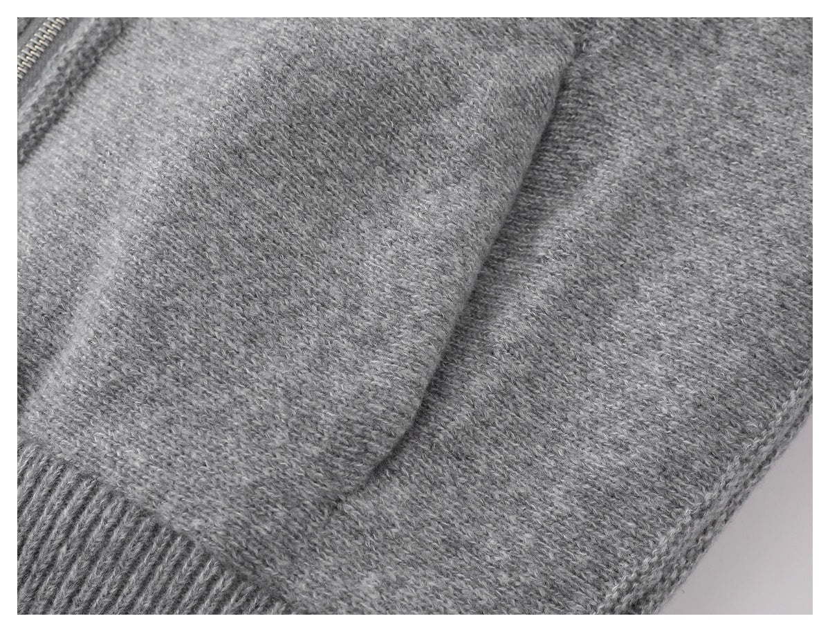 Close-up of gray knit fabric, a seam, and a section of ribbed trim.