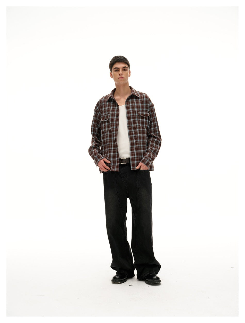 Front-facing model wearing a brown plaid button-up over a white tank with loose black trousers.