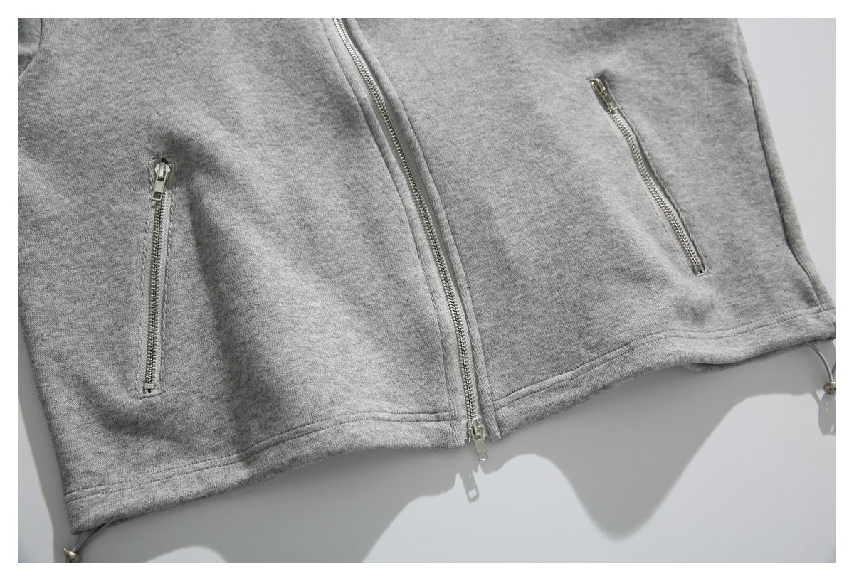 Cropped view of a heather gray zip-front garment with two vertical zip pockets and drawcords at the hem.