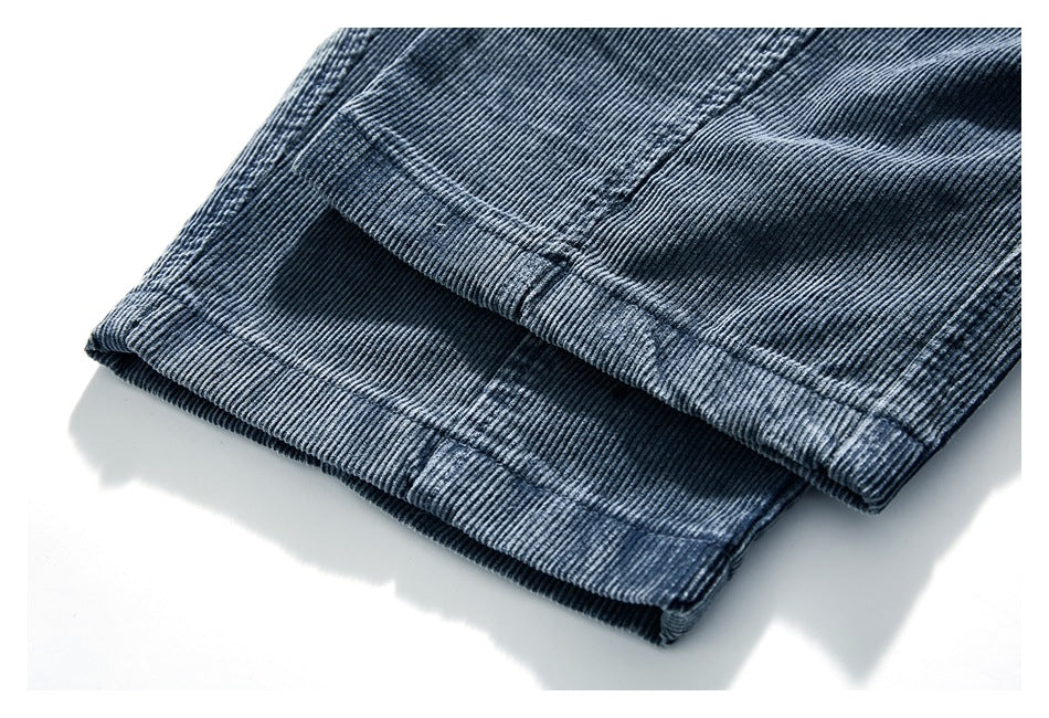 Close-up of the stitched hem on blue-gray corduroy pants.
