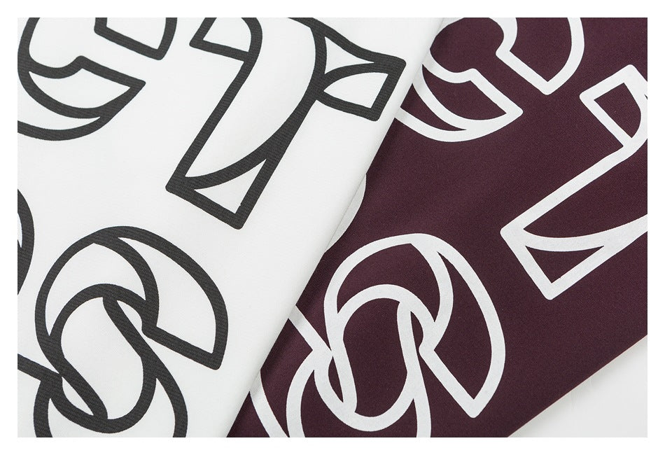 Close-up of white and dark burgundy fabric colorways with large contrasting outlined graphics.