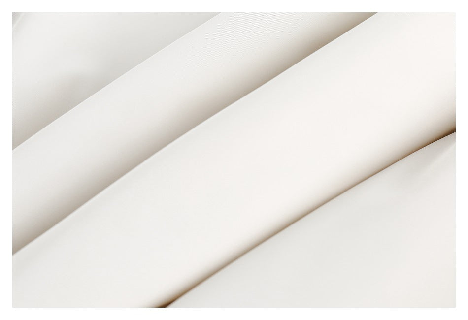 Macro view of smooth white garment fabric folded into overlapping diagonal layers.