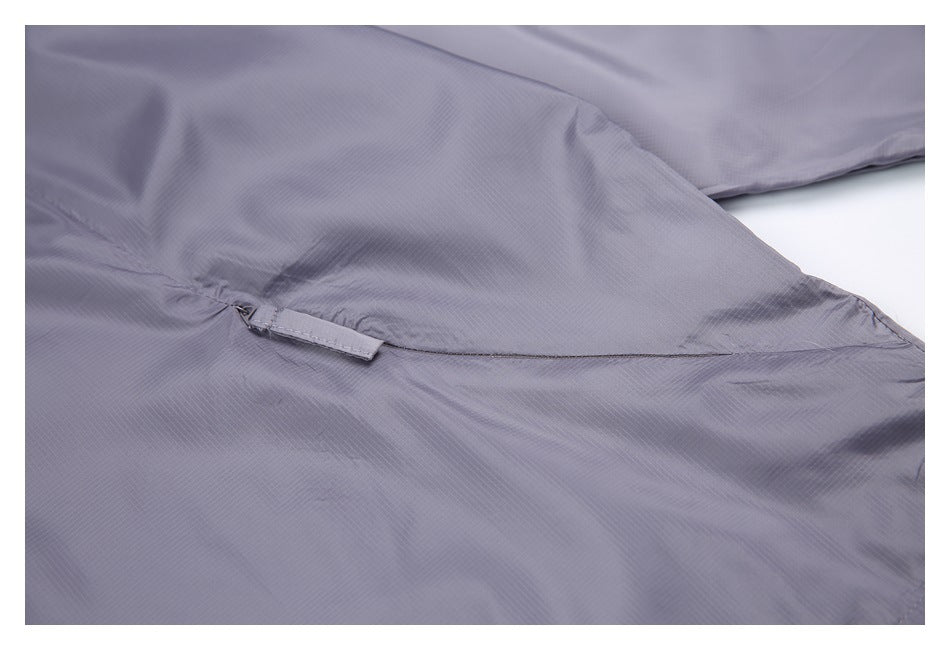 Close-up of a stitched pocket flap and small fabric tab on the gray-lavender jacket.