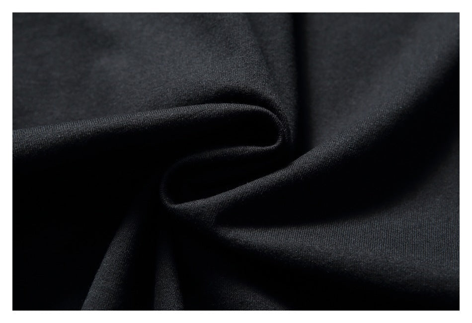 Extreme close-up of black T-shirt fabric gathered into soft folds.
