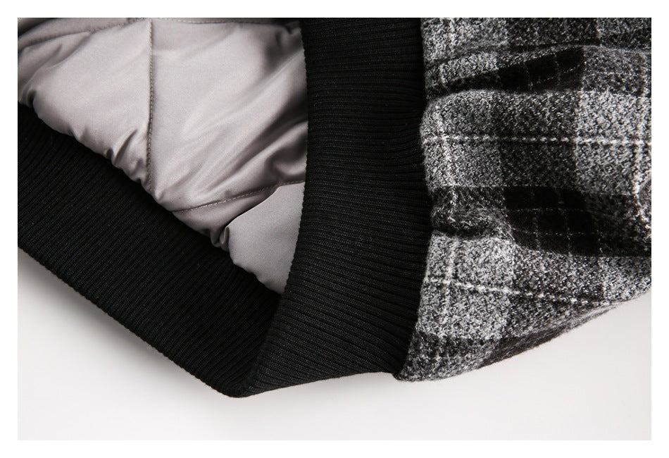 Close-up showing the jacket's black ribbed hem and pale gray inner lining beside the plaid exterior.