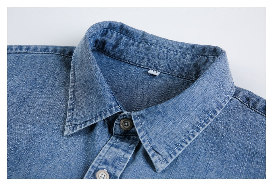 Close view of a blue button-up shirt laid flat, showing its pointed collar and upper front.