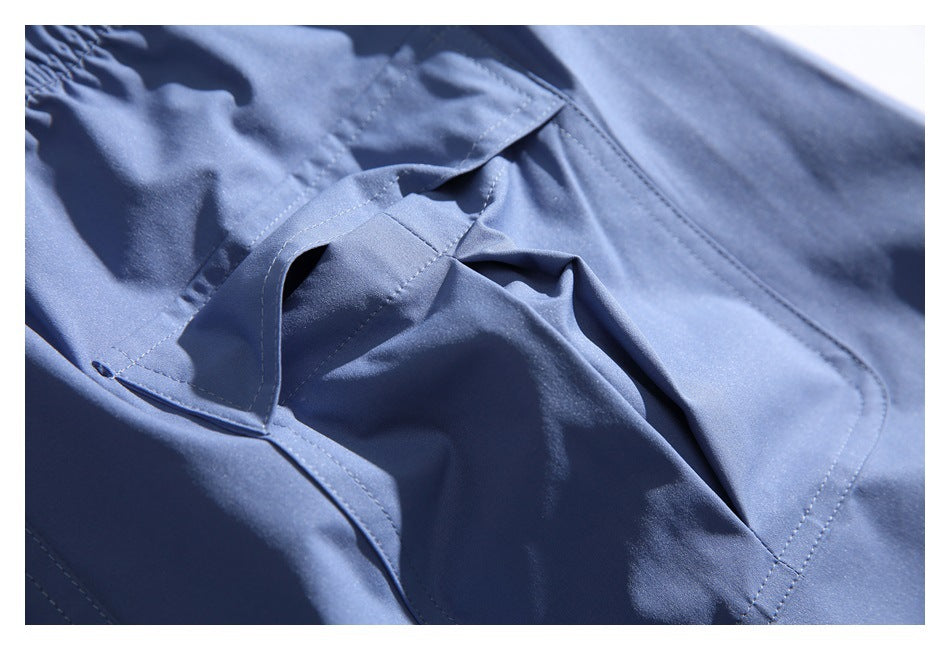 Close-up of the opening and stitched flap of a blue cargo trouser pocket.