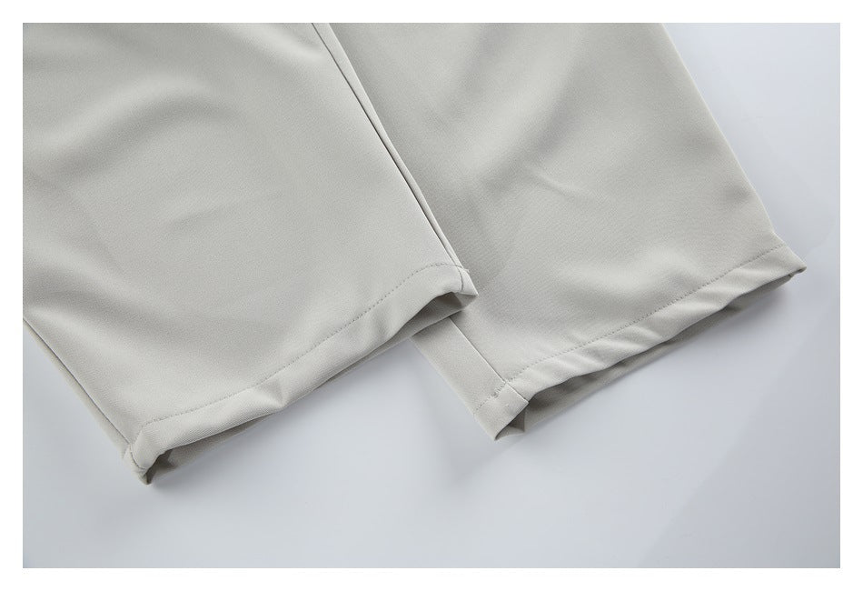 Close-up of the finished hems on light beige trouser legs.