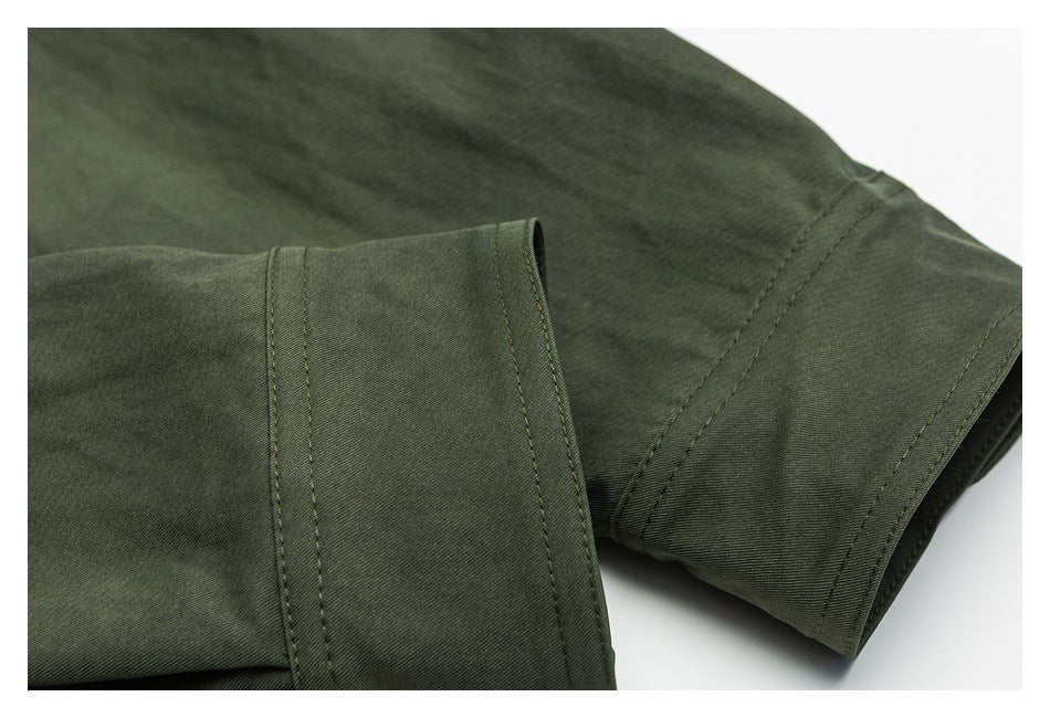 Close-up of a dark olive sleeve and cuff with parallel rows of stitching.