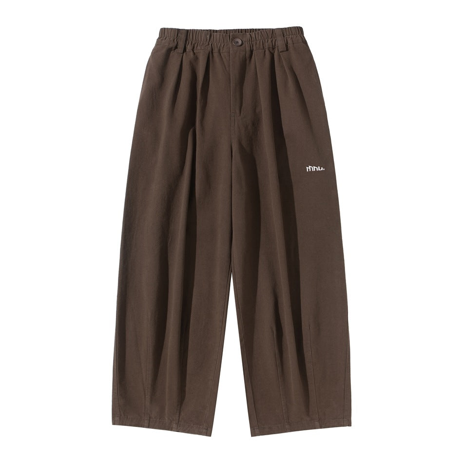 Coffee brown wide-leg pleated pants with elastic waistband, button front and small logo, flat front view