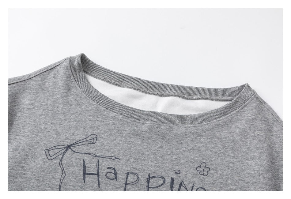 Close-up of a gray sweatshirt's ribbed crew neck and upper chest with part of its hand-drawn print visible.