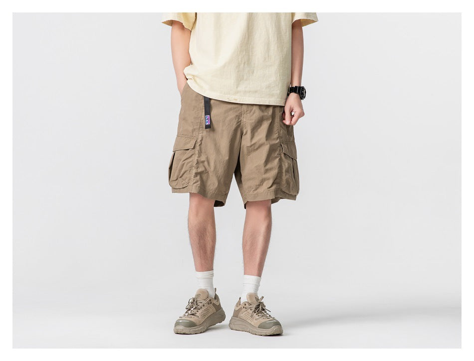 Front view of a model wearing tan cargo shorts with oversized side pockets.
