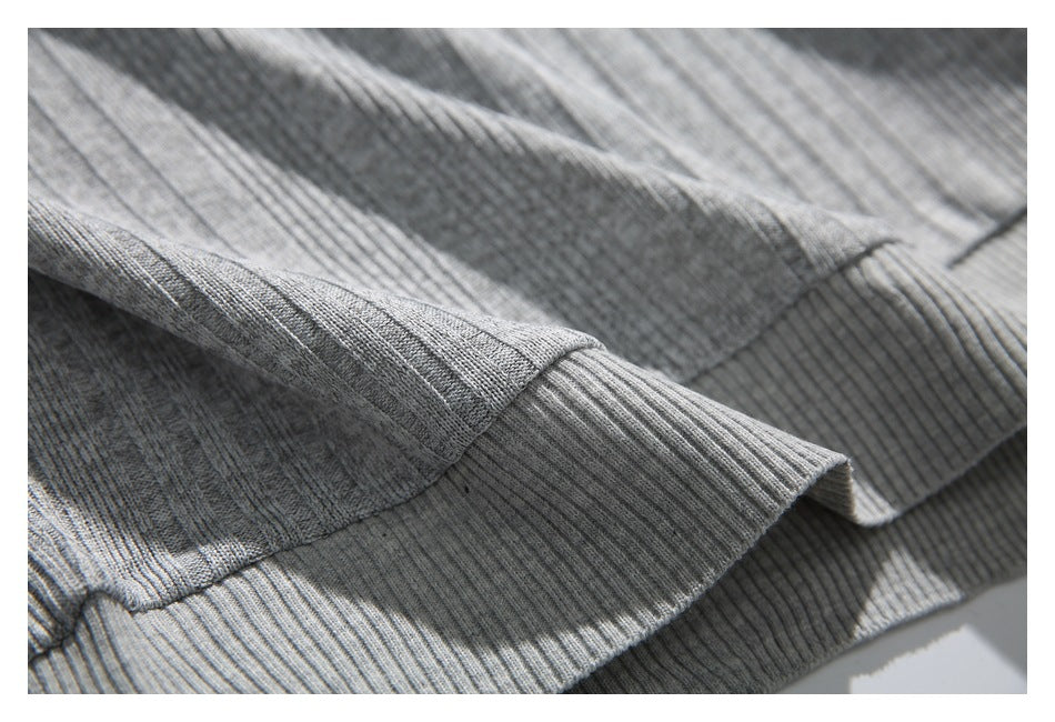Close-up of gray ribbed knit fabric with a wide folded edge and visible stitching.