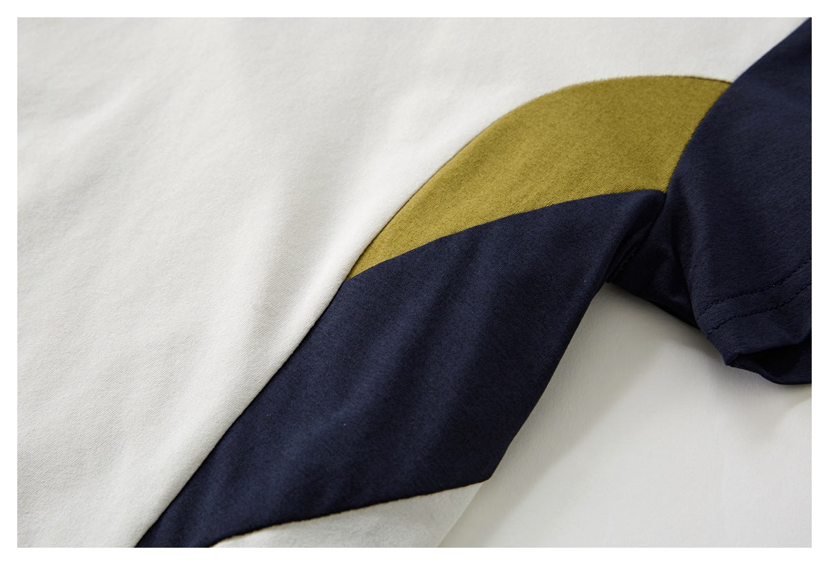 Close-up of the shirt's navy and mustard color-block sleeve against ivory fabric.