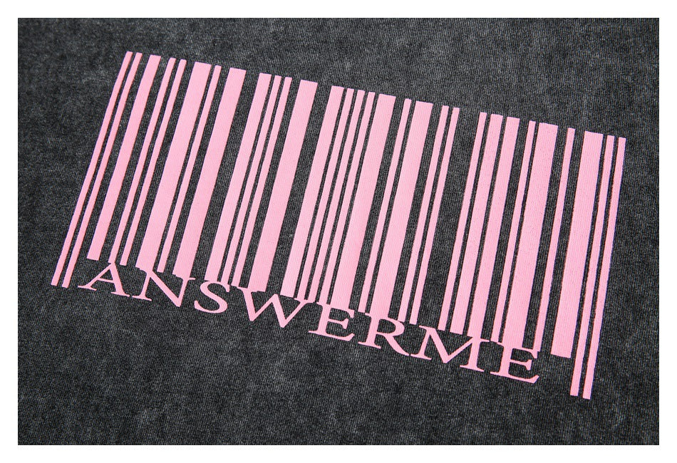Close-up of a pink barcode-style graphic and “ANSWERME” lettering printed on dark charcoal fabric.